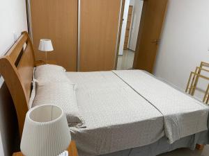 a bedroom with a bed with a white blanket at Simas Confort Plateau in Praia