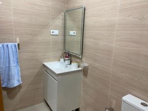 a bathroom with a white sink and a mirror at Simas Confort Plateau in Praia