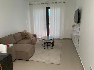 a living room with a couch and a table at Simas Confort Plateau in Praia