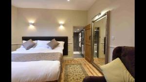 a hotel room with two beds and a mirror at Sutherland House in Southwold