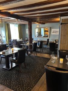 a restaurant with tables and chairs and a mirror at Sutherland House in Southwold