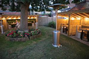 a garden with a tree and a table and flowers at Sutherland House in Southwold