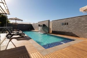 a swimming pool with lounge chairs on a wooden deck at Hotel Parada Linares in Linares