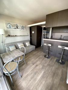 a living room with a couch and a table and chairs at Appartement vue mer Hossegor in Soorts-Hossegor +9 photos