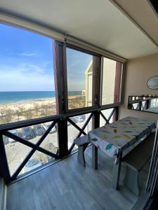 a balcony with a table and a view of the ocean at Appartement vue mer Hossegor in Soorts-Hossegor