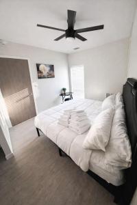 a bedroom with a large white bed with a ceiling fan at The Luxe Black Haven (340) in Des Moines