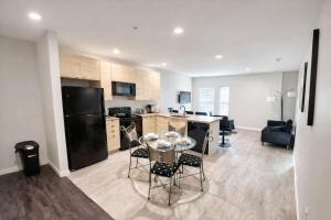 a kitchen with a black refrigerator and a table and chairs at The Luxe Black Haven (340) in Des Moines