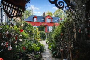 a garden with a red house in the background at Au2 Maison d'Hôtes - Guest House Au2 in Muidorge