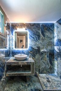 a bathroom with a sink and a mirror at 3 Goddesses' studios in Koukounaries