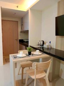 a kitchen with a table and two chairs and a counter at Baba Staytion 1-2-3 of SMDC Style Condo in Iloilo City