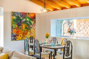 a dining room with a table and chairs and a painting at Espectacular apartamento a 10 minutos de Pamplona in Uterga