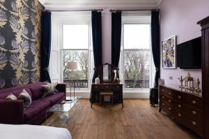 a living room with a purple couch and two windows at 24 Royal Terrace in Edinburgh