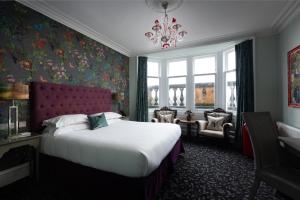 a hotel room with a bed and a chandelier at 24 Royal Terrace in Edinburgh