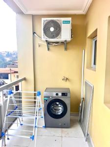 a washing machine in a room with a fan at Cosy Appartment in Yaoundé