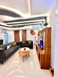 a living room with a couch and a tv at Cosy Appartment in Yaoundé