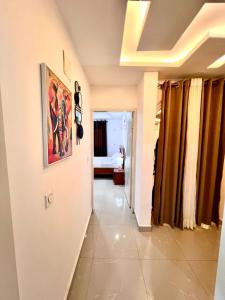 a hallway of a room with a painting on the wall at Cosy Appartment in Yaoundé +2 photos