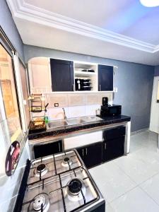 a kitchen with a stove top oven in a room at Cosy Appartment in Yaoundé
