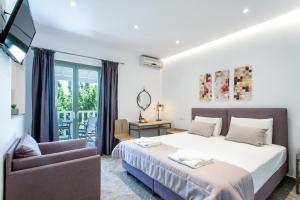 a bedroom with a bed and a chair at 3 Goddesses' studios in Koukounaries