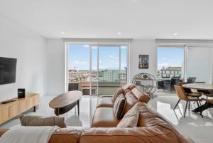 a living room with a leather couch and a table at Penthouse by the Marina in Lagos