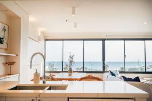 a kitchen and living room with a view of the ocean at Luxury Beach View Escape in Melbourne +18 photos