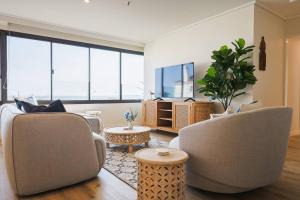 a living room with two chairs and a table at Luxury Beach View Escape in Melbourne