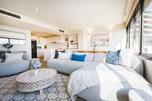 a living room with a couch and a table at Luxury Beach View Escape in Melbourne