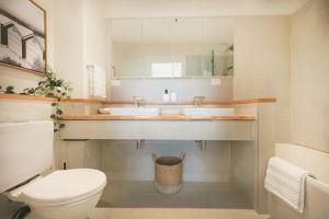 a bathroom with two sinks and a toilet at Luxury Beach View Escape in Melbourne