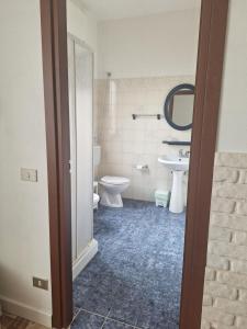 a bathroom with a toilet and a sink and a mirror at B&B Casa Piras IUN3880 in Barùmini +51 photos
