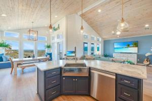 a large kitchen with a sink and a living room at Horizon House Stay. Relax. Repeat. in Port Aransas