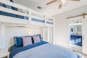a bedroom with a blue bed in a white room at Horizon House Stay. Relax. Repeat. in Port Aransas +105 photos