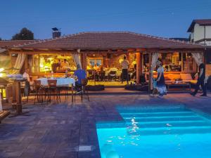a swimming pool in front of a restaurant at night at Five stars in Dubrava