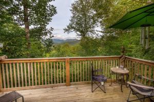 a deck with chairs and a table and an umbrella at Summerset Ridge in Cullowhee