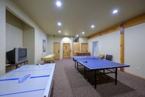a room with two ping pong tables and a tv at Basin Lakeside Getaway MH702Near Powder Mtn Hot Tub in Eden