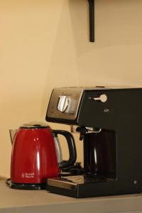 a coffee maker with a red tea kettle on a counter at Le Petit Provençal in Sénas