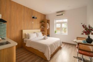 a small bedroom with a bed and a sink at Chạm's Hotel & Homestay in Ho Chi Minh City