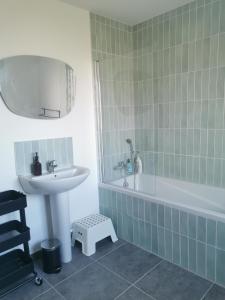 a bathroom with a sink and a bath tub and a sink at Maison spacieuse - Perros Guirec in Perros-Guirec +6 photos