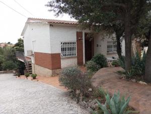 a small white house with a porch and a driveway at Un lugar tranquilo y relajado en Pedrasanta in La Salud