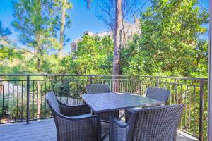 a table and chairs on a deck with trees at Harbour Town Haven in Hilton Head Island