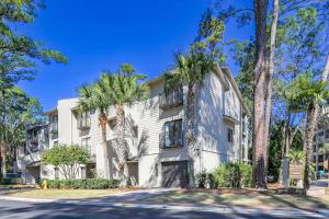an apartment building with palm trees in front of a street at Harbour Town Haven in Hilton Head Island
