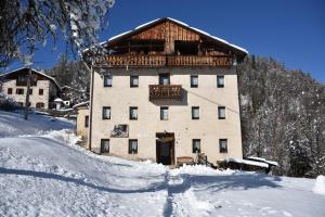 a large building with a balcony in the snow at Mezzodì Locazione Turistica in Colcerver
