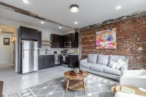 a living room with a couch and a brick wall at Park Hotel 2BR Suite 406 in Chattanooga