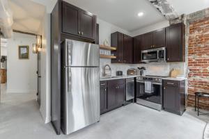 a kitchen with brown cabinets and a stainless steel refrigerator at Park Hotel 2BR Suite 406 in Chattanooga