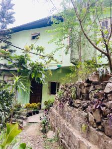 a house with a stone wall in front of it at Maple Homestay in Kohīma