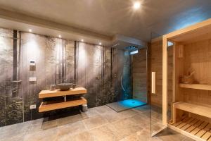 a bathroom with a shower with a sink and a glass shower at Relais del Borgo in Lentiai