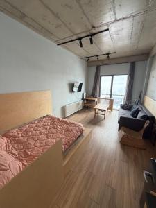 a bedroom with a bed and a couch and a desk at Art house in Kʼumlistsʼikhe