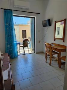 a living room with a view of a table and chairs at EYTYXHS Studios in Palaiochora +29 photos