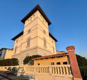 a tall building with a fence in front of it at La Torre in San Vincenzo