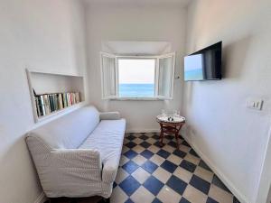 a small living room with a couch and a window at La Torre in San Vincenzo
