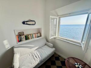 a room with a couch and a window with the ocean at La Torre in San Vincenzo