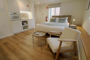 a bedroom with a large bed and a table and chairs at Rossio Garden Suites in Lisbon